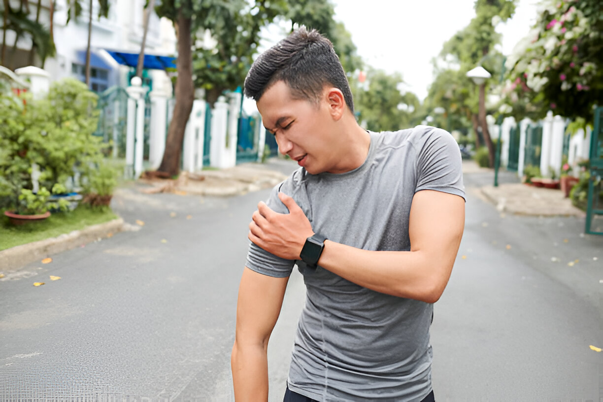 Man on street having a shoulder dislocation.